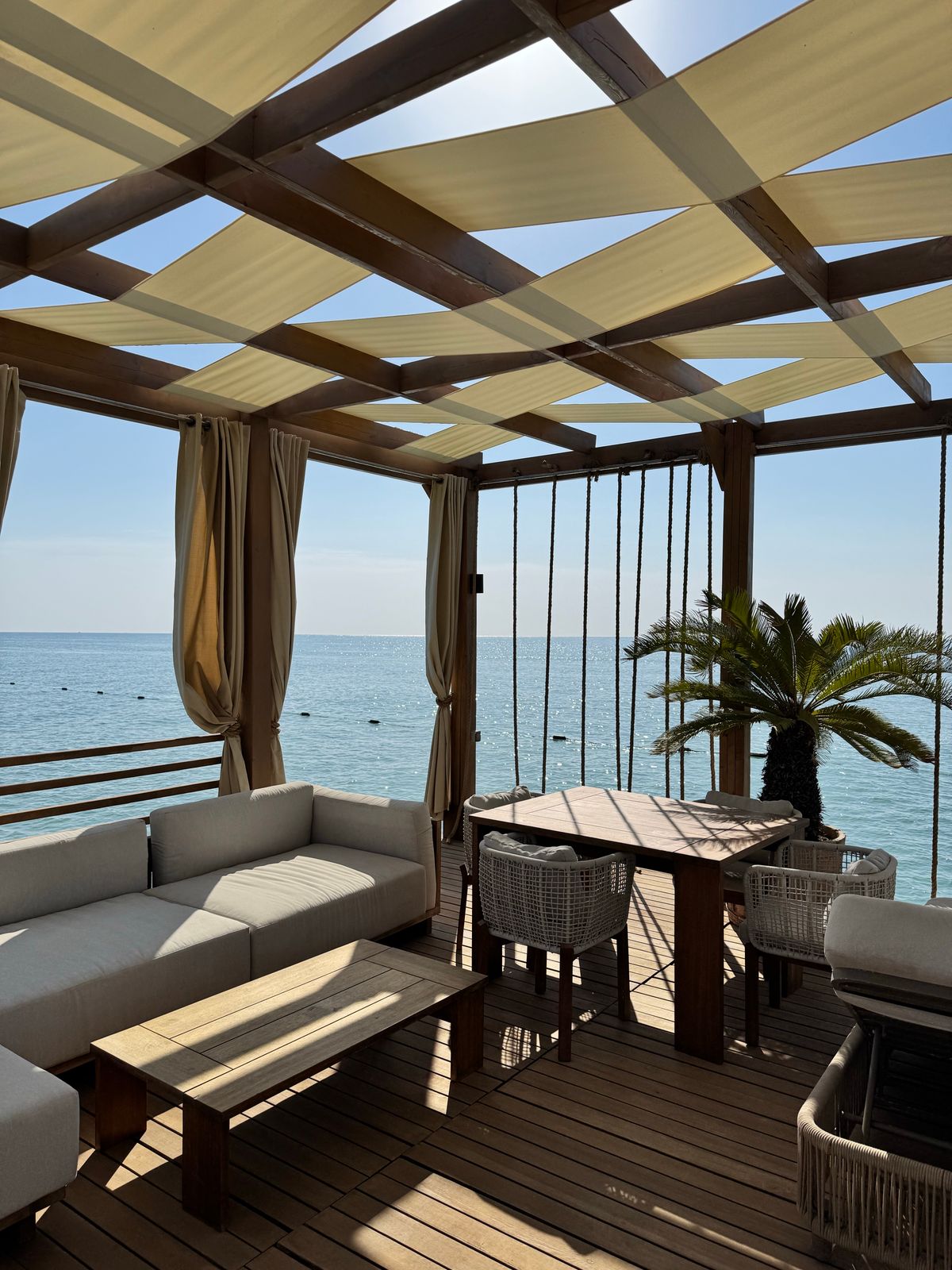 Sunlit timber alfresco pergola and deck overlooking the ocean